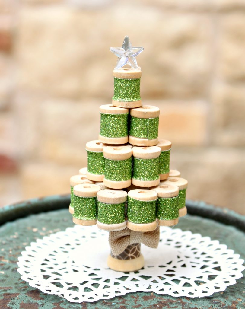 Turn tiny wooden spools into an adorable miniature Christmas tree ornament! Fun project to make and to display. I