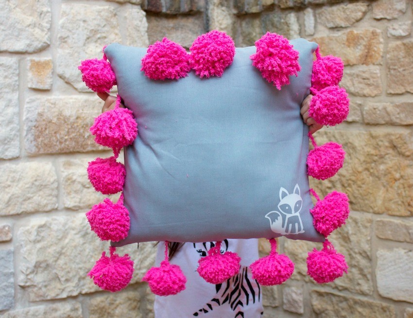 This pom pom pillow tutorial is an adorable and easy to make piece of home decor. This fluffy and fuzzy accent pillow makes a great gift, too.