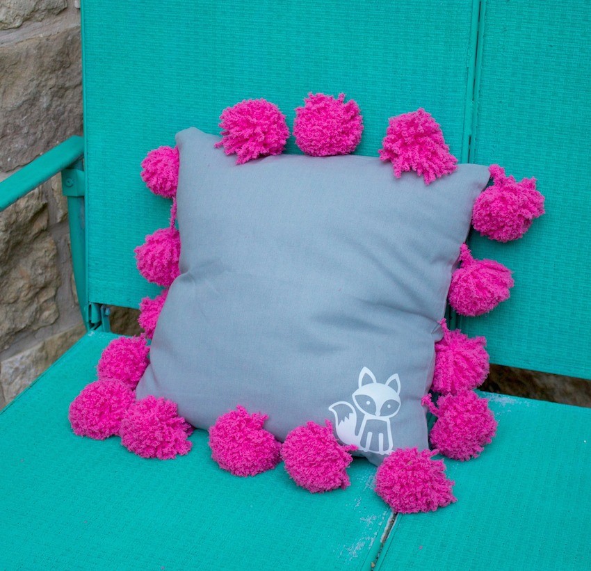 This pom pom pillow tutorial is an adorable and easy to make piece of home decor. This fluffy and fuzzy accent pillow makes a great gift, too.