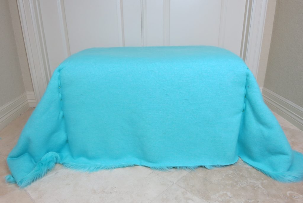 For example, if you measure 48" from the front to the back of the ottoman and 36" from one side to the other side, then you will cut a rectangle of fur fabric that is 48x36 inches. I used approximately 2 yards of fabric for my ottoman makeover.