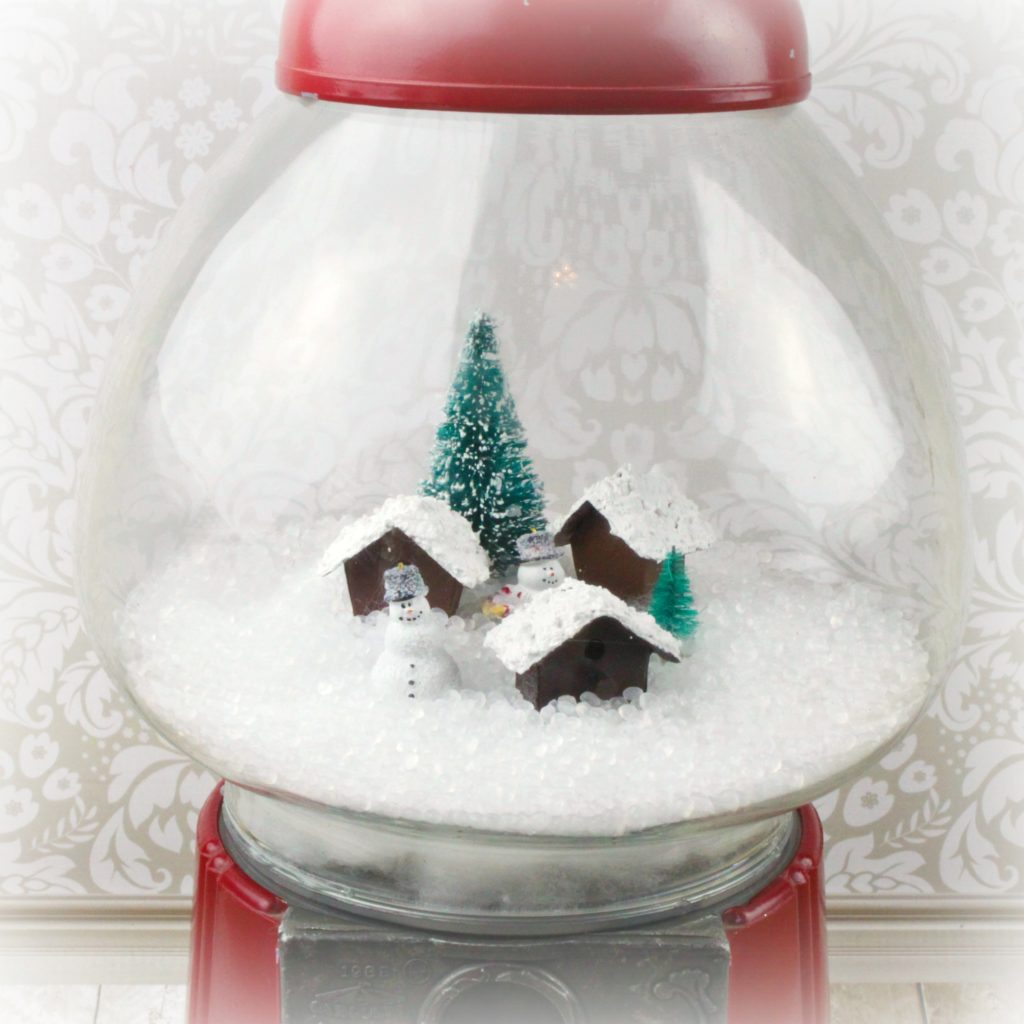 Make a gumball machine snow globe using a thrift store item with various craft supplies. Make adorable holiday Christmas and winter decor!