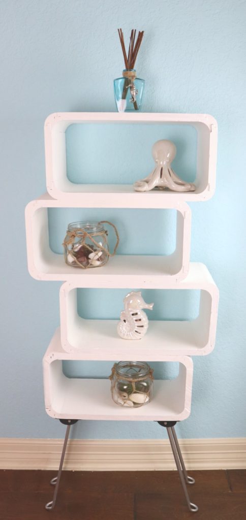 This mod shelf DIY is my version of an expensive furniture item. I used wood floating shelves PLUS a table from Goodwill to make my own storage shelf.