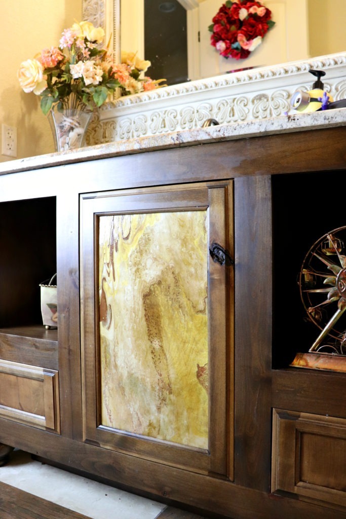If you haven't caught on to the paint pouring craze yet, let me warn you. It's addicting. DecoArt introduced a new line of paint pouring products, and I decided to try my hand at it. My first project was to tackle this unfinished door that's bothered me for years. I chose colors that matched the stone countertops and got to pouring.