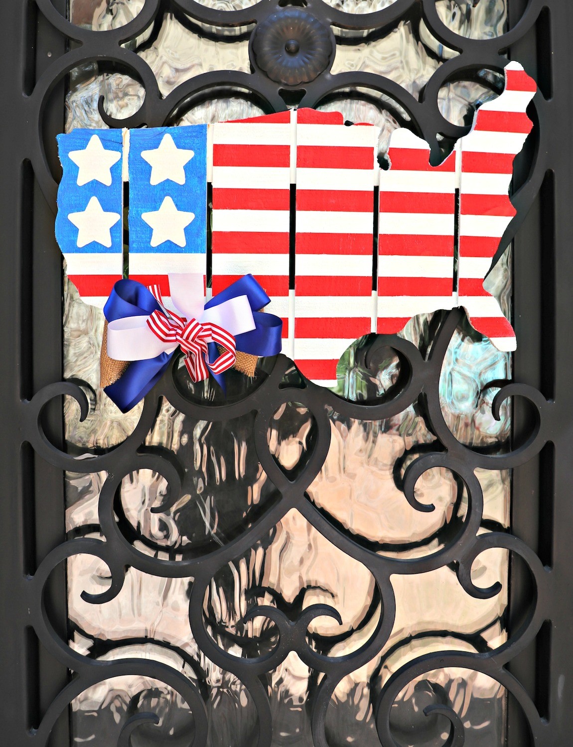 Make patriotic door decor using a cut pallet shaped like the United States. This painted piece is great for Fourth of July and other US holidays.